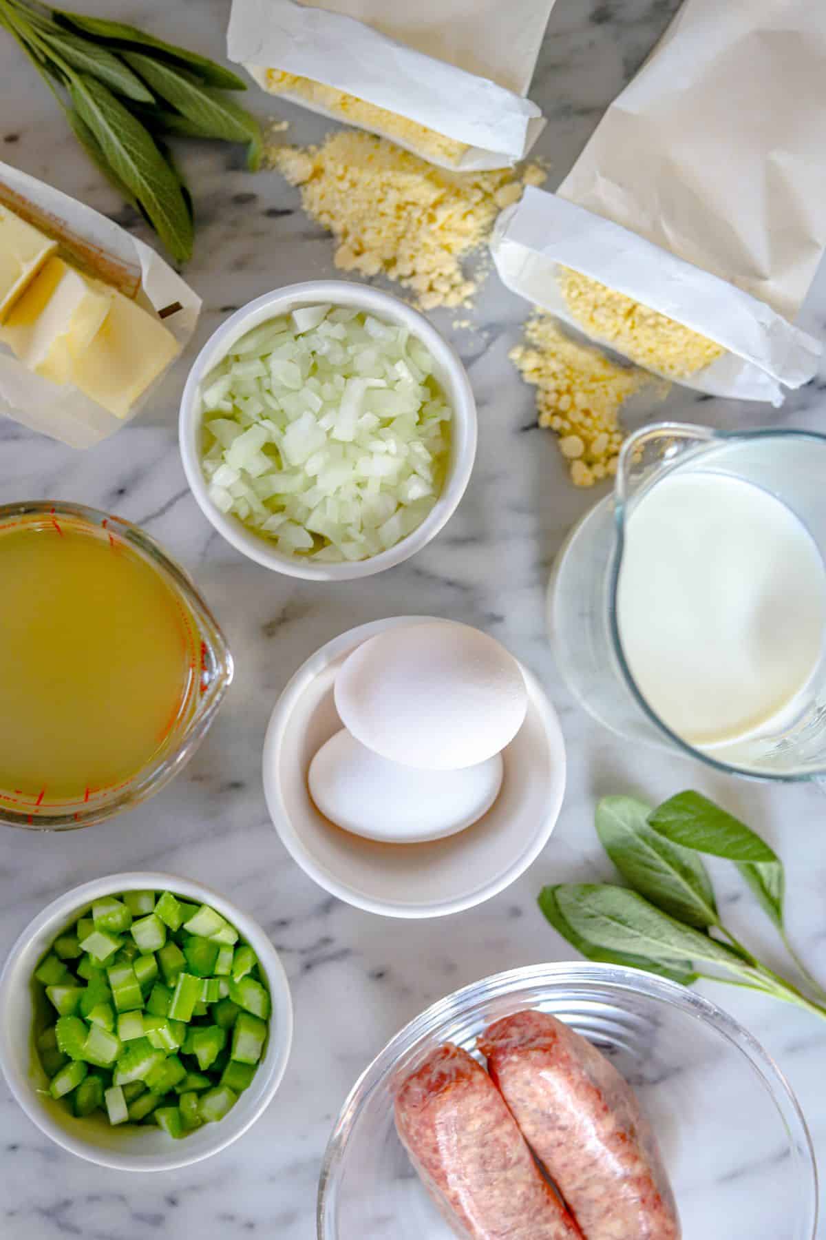 Jiffy cornbread dressing ingredients - salted butter, fresh sage, 2 packets of jiffy corn muffin mix, milk, eggs, chicken broth, chopped celery, chopped onions, sausage links.