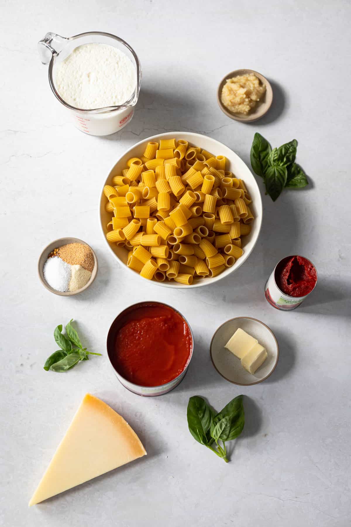 ingredients for pink sauce pasta - heavy cream, crushed garlic, fresh basil, tomato paste, unsalted butter, tomato puree, parmesan cheese, garlic and onion powder, salt.