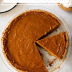 sliced sweet potato pie with graham cracker crust in a glass pie plate.