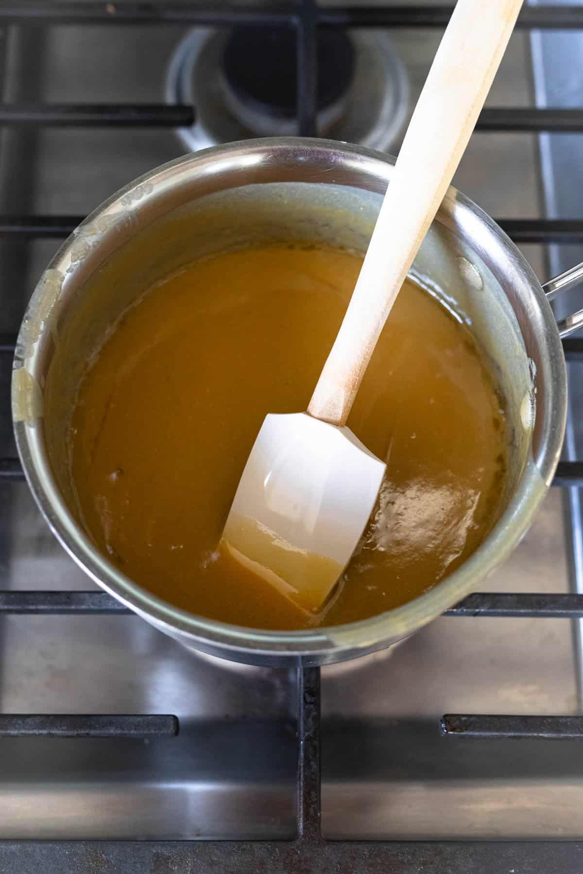 light brown bourbon sauce in a saucepan on the stovetop.