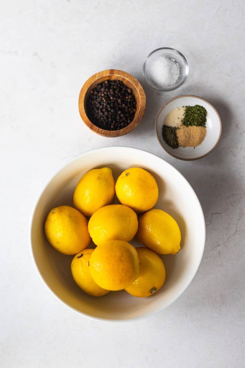 lemon pepper seasoning ingredients - whole black peppercorns, 8 fresh lemons, kosher salt, gerlic powder, onion powder, dried thyme and dried parsley.