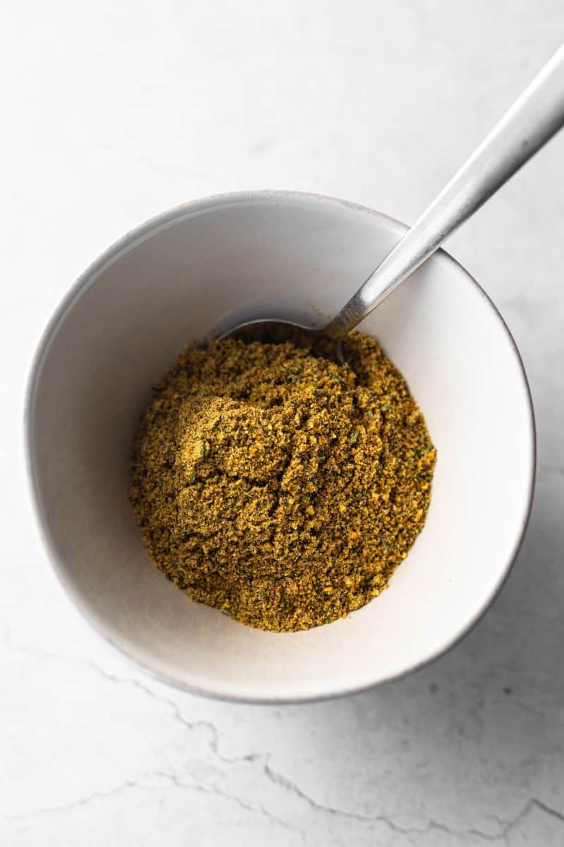 homemade lemon pepper seasoning in a small bowl with metal spoon.