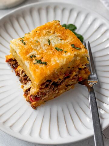 Slice of pastelon de platano maduro (plantain lasagna) on a white plate.