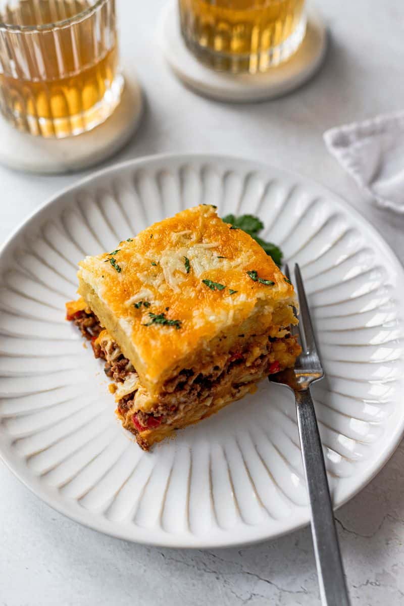 Slice of pastelon de platano maduro (plantain lasagna) on a white plate.