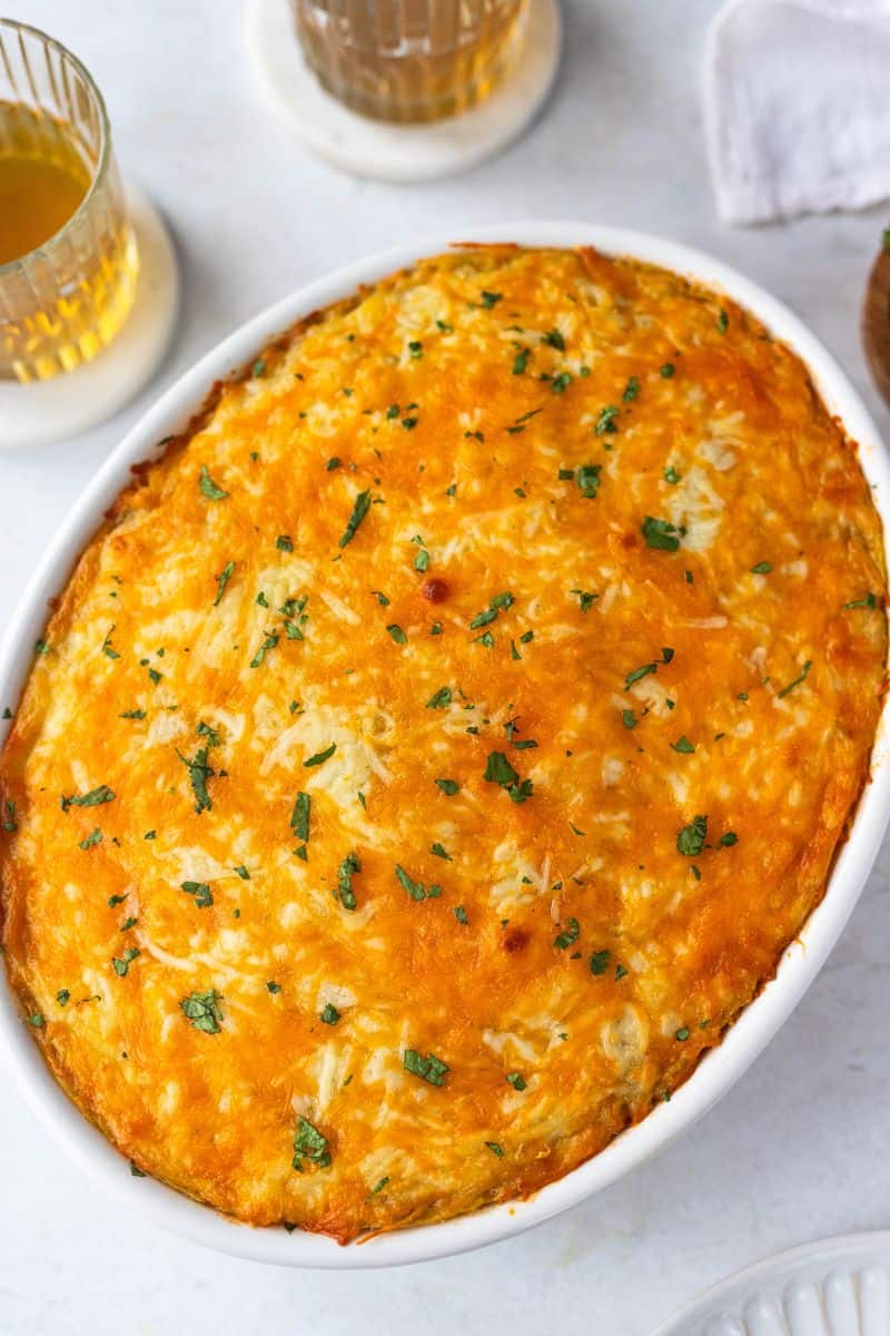 Baked pastelon de platano maduro (plantain lasagna) in a round baking dish.