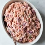 Dominican pink potato salad with beets in a white bowl.