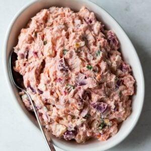 Dominican pink potato salad with beets in a white bowl.