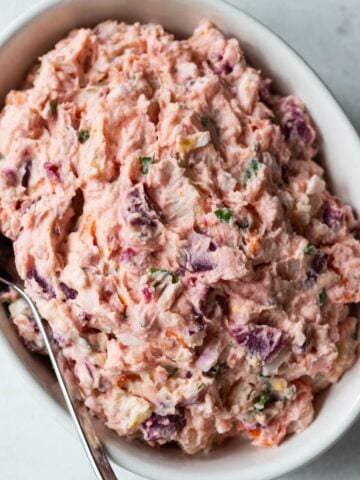 Dominican pink potato salad with beets in a white bowl.